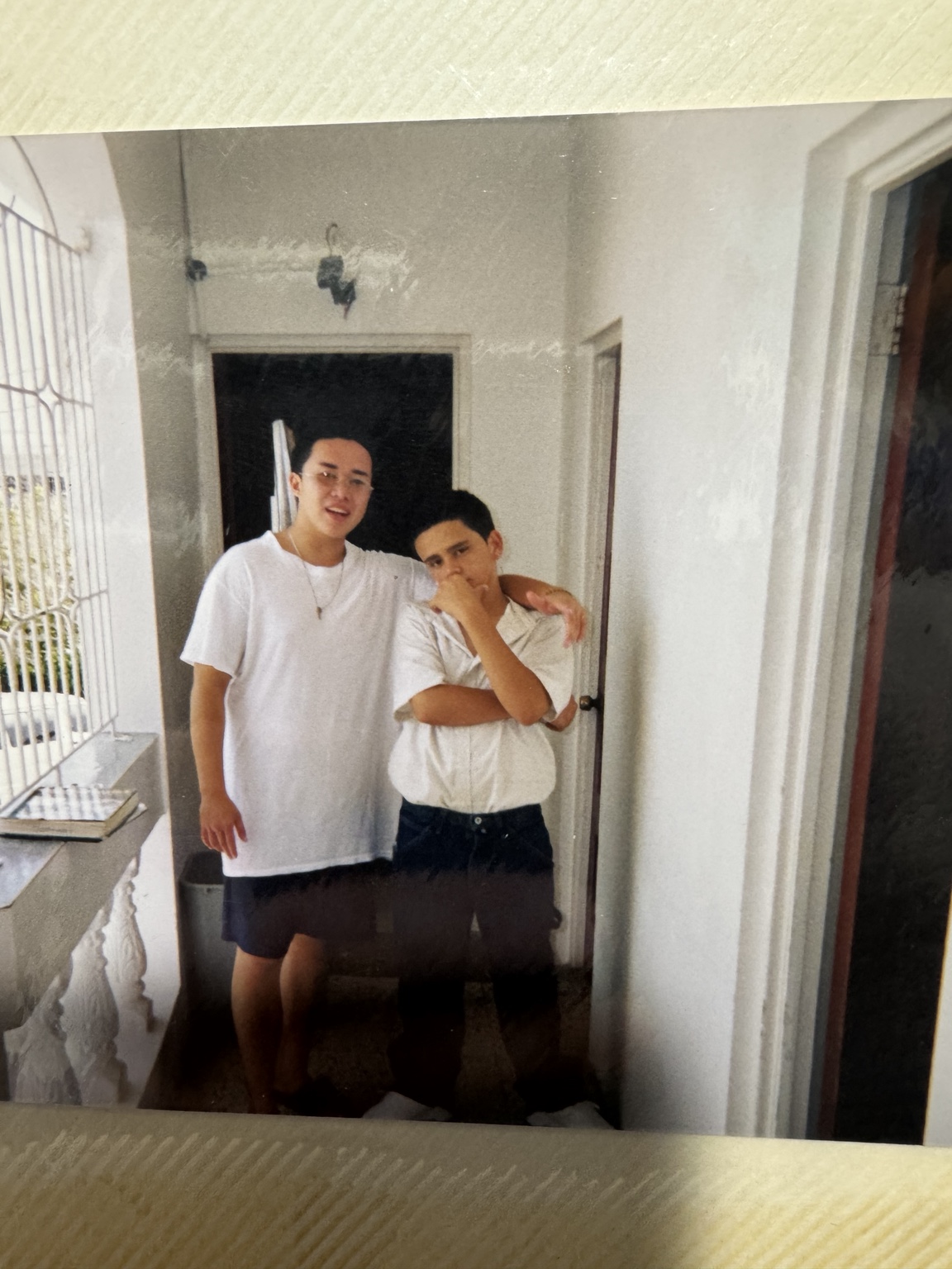 An original album photograph of two people standing together in a corridor.